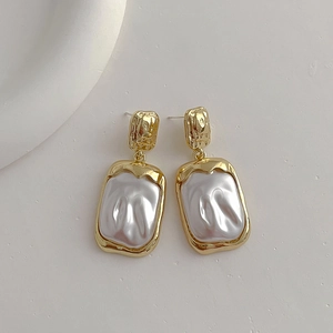 Close-up of vintage resin square stud earrings with hammered gold metal texture