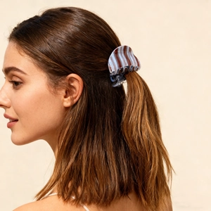 Detail of blue and brown striped claw clip worn by model for elegant hairstyle styling