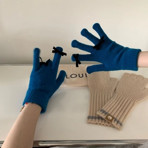 Close-up of winter knit gloves with black ribbon bows and soft touch-screen fabric
