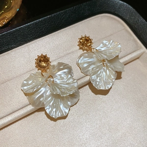 Detail view of pearl petal tassel earrings with gold setting and amber crystal inlay