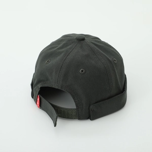 Detail view of dark grey kids beanie with adjustable velcro strap and red tag accent