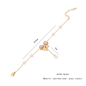 Detailed view of golden butterfly bracelet with purple heart glass and pearl beads