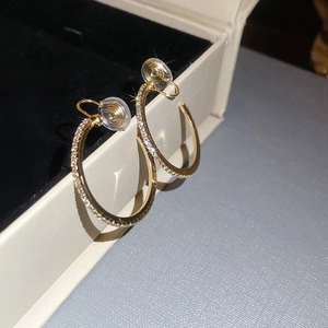 Macro shot of sparkling gold hoop earrings with diamonds on a premium jewelry box