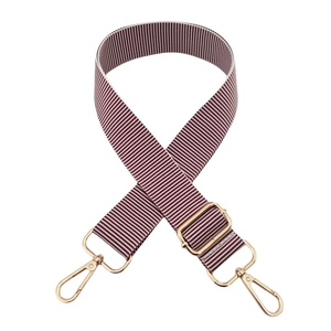 Detail of burgundy and white striped woven bag strap with golden metal hardware clips