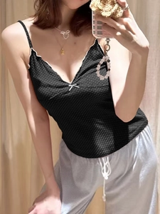 Detailed view of black polka dot camisole with white lace trim and bow detail