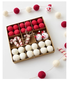 Detail of wool felt Christmas ornaments set in a kraft paper box with Santa and candy canes