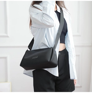 Detalle de la correa ancha ajustable en un bolso bandolera de nailon negro
