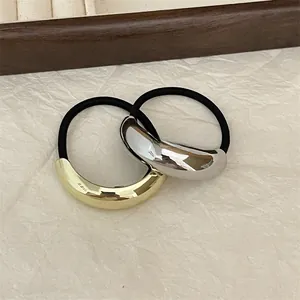 Detail of gold and silver minimalist metal hair rings on black elastic hair ties