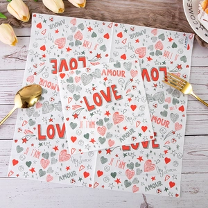 Romantic Valentine's Day paper napkins with heart patterns and love quotes on wooden table