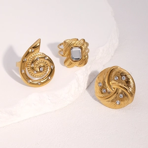 Set of 18k gold plated titanium steel rings with rhinestones on white marble display
