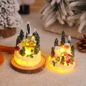 Detail of light-up resin Christmas cottage with Santa and snowman figurines