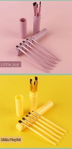 Detailed view of portable makeup brush sets in pink and yellow with matching storage tubes