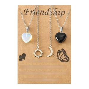Detail view of friendship necklace set with sun, moon, and heart charms on card