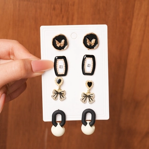 Detail of a 4-pair earring set featuring golden butterflies and geometric enamel designs