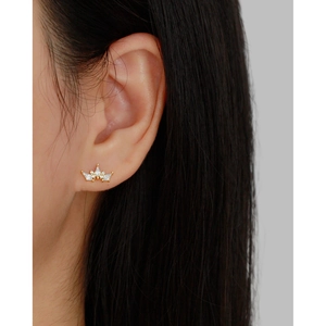Luxurious gold crown stud earrings with sparkling zircons worn by a model in a close-up shot