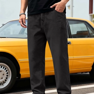Détail d'un jean droit en denim tencel noir sur fond de voiture de collection jaune vif