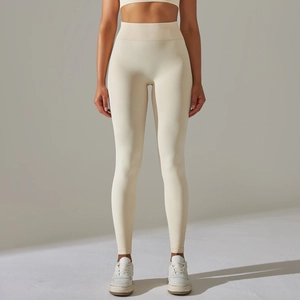 Seamless high waisted cream yoga pants for women featuring ribbed texture and slim fit