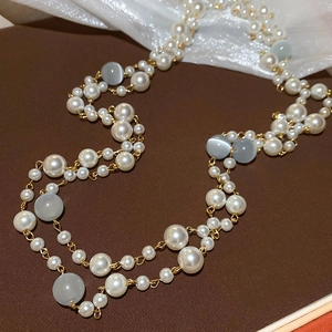 Détail de perles plaquées or et de pierres œil de chat sur le collier de perles