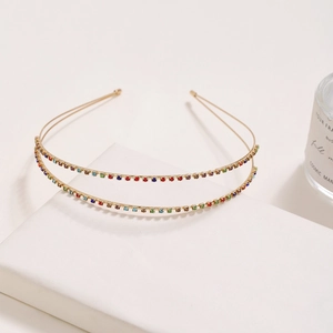 Detail of a thin gold double-layered headband featuring sparkling colorful rhinestones
