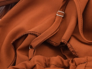 Detailansicht der verstellbaren dünnen Träger und Metallschnallen am caramel Kleid
