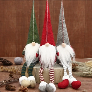 Three Christmas gnomes with long striped legs sitting on logs, Nordic holiday decor