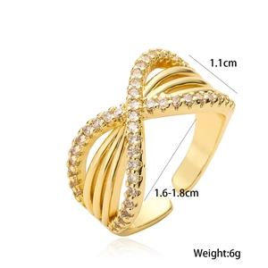 Cross-over gold plated open ring with cubic zirconia stones shown on white background
