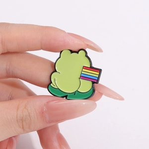 Cartoon green frog enamel pin on lily pad with rainbow flag, crafted in zinc alloy
