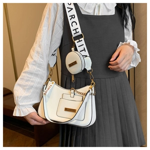 Close-up of white leather shoulder bag with detachable coin purse and brand logo
