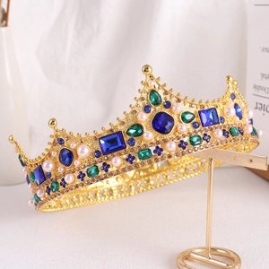 Detail of a Baroque queen crown with blue crystals and white pearls on a gold stand