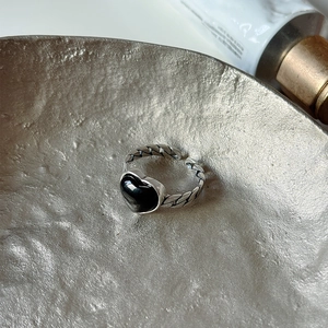 Detail view of S925 sterling silver ring featuring a black heart stone and woven band