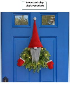 Light-up Christmas gnome wreath with green pine branches on a blue wooden door