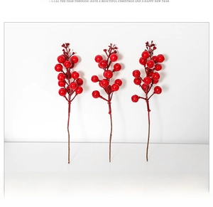 Close-up of three artificial red berry stems for Christmas tree decoration on white backdrop