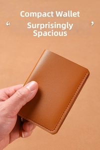Close-up of brown litchi grain leather wallet showing fine stitching and compact texture