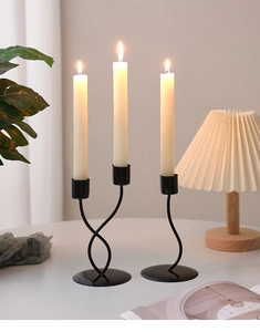 Close-up of modern black iron candle holders with spiral design and matte finish