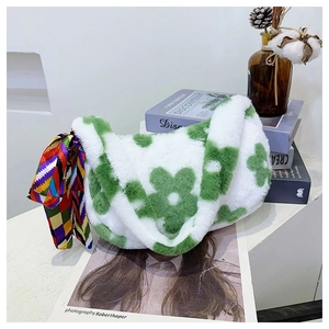 Detail of white plush shoulder bag with green floral patterns and colorful silk scarf accessory