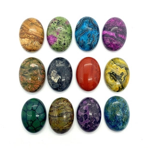 Close-up of assorted oval natural stones including agate and jasper for DIY jewelry