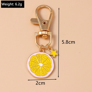 Detailed view of pink and yellow lemon slice keychain with a golden star pendant charm