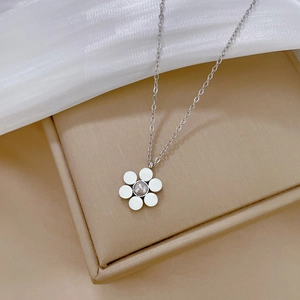Close-up of a silver flower necklace with a center bead on a soft jewelry box display