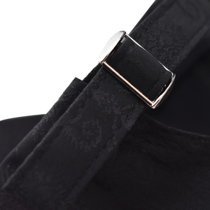 Detail of adjustable black fabric strap with polished silver metal buckle on cotton cap