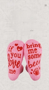 Detail of pink fuzzy socks with anti-slip silicone letters 'bring me some beer' on the sole