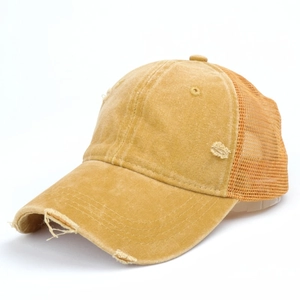 Detailed macro view of vintage distressed wash cotton and mesh on yellow trucker hat