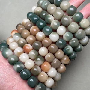 Macro view of polished bodhi root beads with carved mantra patterns in multiple colors