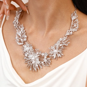 Close-up of silver coral-like necklace with white faux pearls on model neck