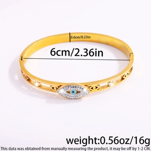 Detailed close-up of gold Evil Eye bangle showing white crystals and blue iris center