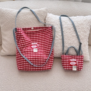 Macro detail of red plaid woven tote bags set with blue straps in a cozy setting