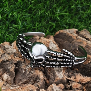Close-up of punk style skull and bone cuff bracelet on natural wood background