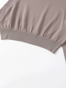 Detailed view of the soft ribbed knit hem on this casual long sleeve mauve sweater