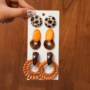 Close-up of bohemian earrings set featuring leopard print resin and woven rattan textures