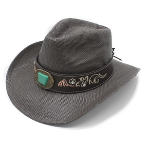 Vue détaillée du chapeau de cowboy en paille avec pierre verte et broderie florale
