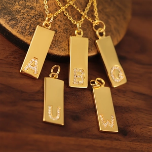 Detailansicht goldener rechteckiger Buchstabenanhänger A B O U W mit Zirkonia-Besatz
